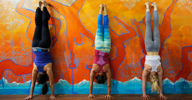 students in a handstand against a wall