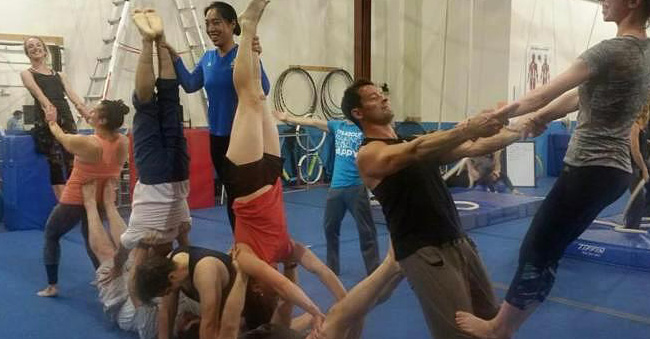 group of people training partner acrobatics