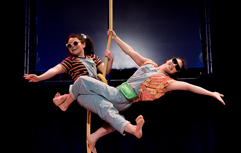 two performers smiling on an aerial rope